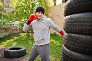 homme boxeur arabe en chapeau s'entraînant pour une salle de sport en plein air de combat acharné. photo