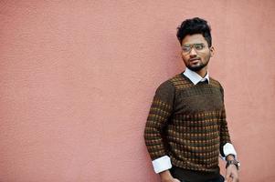 portrait de jeune homme indien élégant modèle à lunettes isolé sur fond de mur rose. photo