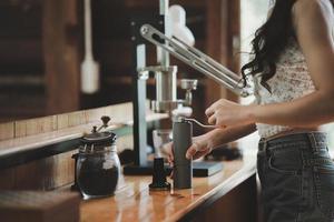 café barista faisant du café avec concept de service de préparation de machine à expresso à levier manuel au restaurant. gros plan main barista faisant du café frais avec une machine à café dans le café. faire du café frais. photo