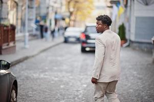 homme afro élégant en costume beige old school. jeune homme africain à la mode en veste décontractée sur torse nu. photo