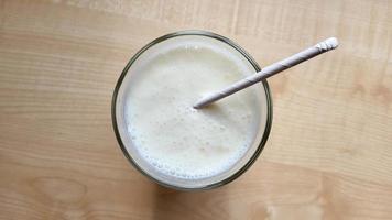 un verre de kéfir sur la table avec un tube en papier photo