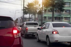 circulation sur les routes de province le soir. abstrait et flou de l'arrière de la voiture rouge avec feu stop allumé. photo