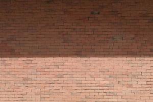 la construction du mur de briques rouges du mur de l'immeuble de grande hauteur pour permettre à la structure d'être solide et durable pour supporter plus de poids est une construction classique mais moderne. photo