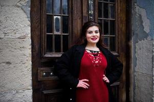 modèle de taille plus brune au rouge dans la rue de la ville. photo