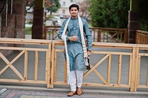 l'homme indien porte des vêtements traditionnels avec une écharpe blanche posée à l'extérieur. photo