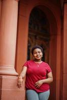 femme africaine porte un t-shirt rouge posant en plein air. photo