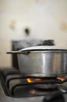 une poêle en aluminium sur une cuisinière avec une flamme entre et sort de la fumée photo