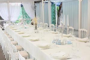 salle de banquet vide prête à recevoir des invités sur la terrasse d'été. table de fête blanche photo