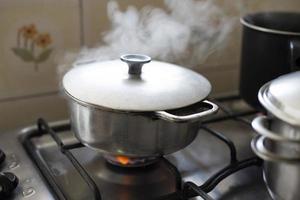 une poêle en aluminium sur une cuisinière avec une flamme entre et sort de la fumée photo