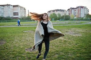 jeune fille brune sur plaid s'amusant le soir du printemps. photo