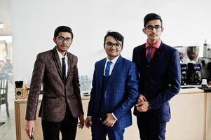 groupe de trois hommes d'affaires indiens en costumes debout sur le café. photo