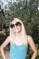 fille blonde avec des sourires de lunettes de soleil photo