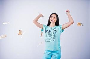 portrait d'une jolie fille en t-shirt et pantalon bleu ou turquoise jetant beaucoup d'argent. photo