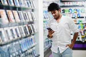 l'acheteur client de l'homme indien au magasin de téléphonie mobile choisit son nouveau smartphone. concept de peuples et de technologies d'asie du sud. magasin de téléphonie mobile. photo