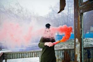 jeune fille avec une bombe fumigène bleue et rouge dans les mains. photo