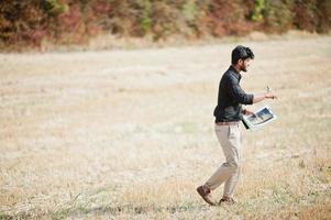 Agriculteur agronome sud-asiatique inspectant une ferme de champs de blé. notion de production agricole. photo