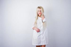 jolie blonde femme médecin ou infirmière en blouse de laboratoire isolée sur fond blanc. photo