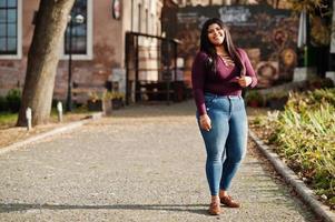 jolie fille modèle latino xxl de l'équateur portant un chemisier violet posé dans la rue. photo