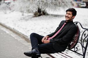 jeune homme indien en costume et cravate posé en plein air en journée d'hiver. photo