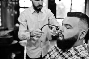 bel homme barbu au salon de coiffure, coiffeur au travail. photo