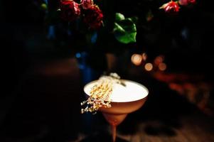 cocktail alcoolisé avec sucre fondu en verre bronze sur table de bar.