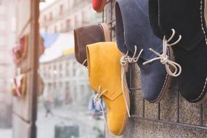 étagères chaussures décontractées accrocher mur devant la boutique l'étagère le magasin à la boutique à la mode. beaucoup de chaussures de toile de baskets mode variété colorée shopping de style de mode en vente. photo