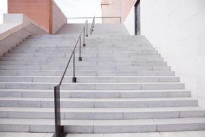 escalier en béton et rampe avec mur de briques au-dessus dans un immeuble résidentiel de l'industrie de la construction. escalier intérieur extérieur. photo