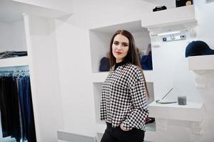 fille magnifique brune dans la boutique du magasin de vêtements à des vêtements décontractés. photo