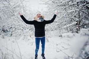 fille blonde s'amusant avec la neige le jour de l'hiver. photo