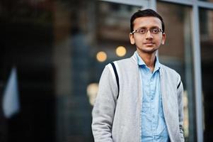 un étudiant indien sud-asiatique porte des lunettes et une pose décontractée en plein air. photo