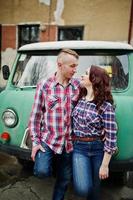 couple élégant portant une chemise à carreaux amoureux ensemble contre une vieille fourgonnette. photo