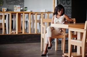 fille afro-américaine assise au café et mangeant des glaces. photo