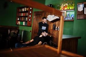 bel homme barbu au salon de coiffure, coiffeur au travail. tête de lavage. photo