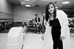 femme sud-asiatique debout au bowling avec ballon sur les mains. fille se prépare pour un lancer. photo