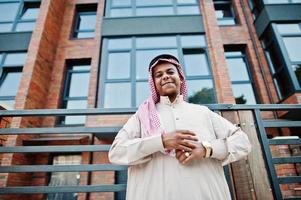 homme arabe du moyen-orient posé dans la rue contre un bâtiment moderne. photo