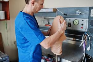 homme prothésiste fabriquant une jambe prothétique tout en travaillant en laboratoire. photo