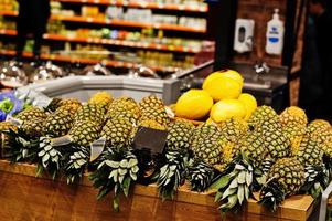 ananas sur des boîtes au supermarché à vendre. photo