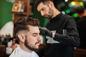 bel homme barbu au salon de coiffure, coiffeur au travail. photo