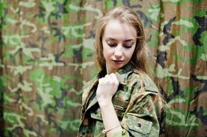 fille militaire en uniforme de camouflage sur fond d'armée. photo