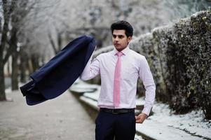 élégant modèle d'homme macho indien en costume et cravate rose posé le jour de l'hiver. photo