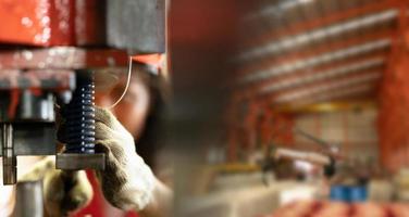 ingénieur portant un casque tout en se tenant dans une usine industrielle lourde derrière avec un arrière-plan d'usine. la maintenance du travail sur des machines industrielles et la configuration du système de sécurité. photo