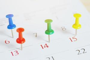 marquer le jour de l'événement avec une épingle. punaise dans le concept de calendrier pour la chronologie occupée organiser le calendrier, rappel de rendez-vous. planification d'une réunion d'affaires ou d'un concept de planification de vacances de voyage. mise au point douce photo