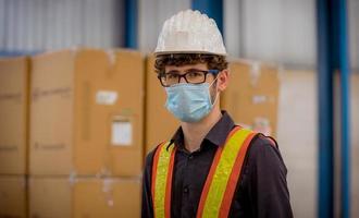 ingénieur d'usine sous inspection et vérification du processus de production de qualité sur la station de fabrication de masques faciaux en portant un uniforme décontracté et un casque de sécurité dans la plantation d'usine. photo