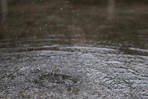 gouttes de pluie dans l'eau lourde sur l'asphalte ombre d'ombre noire et reflet du ciel sombre dans la ville. contraste élevé en automne photo