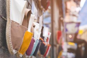 étagères chaussures décontractées accrocher mur devant la boutique l'étagère le magasin à la boutique à la mode. beaucoup de chaussures de toile de baskets mode variété colorée shopping de style de mode en vente. photo