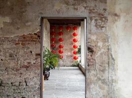 l'entrée en béton flou comme avant-plan, lanterne chinoise accrochée au mur. photo