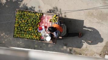 vieil homme pauvre vendant de la mangue photo