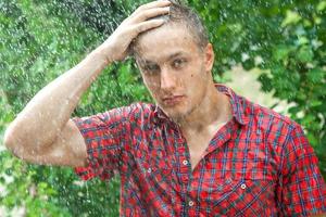 jeune homme sexy mouillé sous la pluie photo