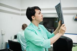 thème médical. une femme médecin tient une radiographie dans le bureau de l'irm au centre de diagnostic de l'hôpital. photo