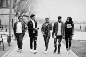 jeunes amis africains de la génération Y marchant dans la ville. des noirs heureux s'amusant ensemble. concept d'amitié génération z. photo